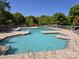 Large community pool surrounded by lush greenery, sun loungers, and clear blue sky at 9517 Harris Glen Dr, Charlotte, NC 28269