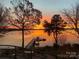 Breathtaking sunset waterfront view showcasing a private boat dock and tranquil waters at 102 Eastham Ct, Mooresville, NC 28117