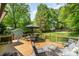 Inviting backyard deck with comfortable seating and an umbrella table surrounded by mature trees at 1043 Nancy Dr, Charlotte, NC 28211