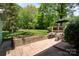 Backyard patio with outdoor seating, a brick retaining wall, and lush green lawn at 1043 Nancy Dr, Charlotte, NC 28211