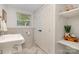 Bathroom with a modern sink, marble floors, decorative shelving, and a geometric wallpaper accent at 1043 Nancy Dr, Charlotte, NC 28211