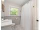 Clean bathroom with a white shower curtain, marble countertop sink, and ample natural light at 1043 Nancy Dr, Charlotte, NC 28211