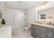 Bright bathroom with a glass enclosed shower, a white tile, and double sink vanity at 1043 Nancy Dr, Charlotte, NC 28211