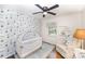 Bright bedroom with a white crib, ceiling fan, and a serene blue wallpaper design at 1043 Nancy Dr, Charlotte, NC 28211