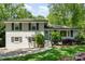Charming two-story home with painted brick, a well-manicured lawn, and beautiful landscaping at 1043 Nancy Dr, Charlotte, NC 28211
