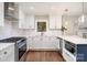Modern kitchen featuring white cabinets, quartz countertops, stainless steel appliances, and hardwood floors at 1043 Nancy Dr, Charlotte, NC 28211