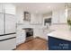 Modern kitchen featuring white cabinets, quartz countertops, stainless steel appliances, and hardwood floors at 1043 Nancy Dr, Charlotte, NC 28211