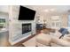 A spacious living room with a stone fireplace, hardwood floors, and an open layout to the kitchen at 1043 Nancy Dr, Charlotte, NC 28211