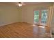 Bright bedroom with hardwood floors, closet, and access to outdoor area through glass paneled double doors at 10708 Danesway Ln, Cornelius, NC 28031