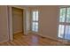 Sunny bedroom featuring plantation shutters, hardwood floors, and built in closet storage at 10708 Danesway Ln, Cornelius, NC 28031