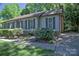 Well-maintained home exterior with neat landscaping, gray siding, dark shutters, and a brick chimney, offering cozy charm at 10708 Danesway Ln, Cornelius, NC 28031