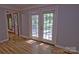 Living room featuring french doors providing access to the porch or sunroom, hardwood floors, and detailed trim at 10708 Danesway Ln, Cornelius, NC 28031