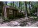 Exterior of a backyard shed featuring a window, offering additional storage in a wooded lot at 10708 Danesway Ln, Cornelius, NC 28031