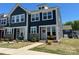 Charming two-story townhome with dark siding, stone accents, manicured lawn, and inviting front porch at 1075 South Point Rd, Belmont, NC 28012