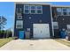 Attached garage with a white door and concrete driveway, complementing the home's dark blue exterior at 1075 South Point Rd, Belmont, NC 28012