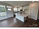 Open-concept kitchen featuring white cabinets, stainless steel appliances, and a center island with granite countertops at 1075 South Point Rd, Belmont, NC 28012