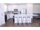 Bright kitchen with white cabinets, stainless steel appliances, center island with barstool seating, and hardwood floors at 1075 South Point Rd, Belmont, NC 28012