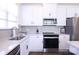 Bright kitchen featuring white cabinets, stainless steel appliances, and a gray backsplash at 1075 South Point Rd, Belmont, NC 28012