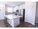 Modern kitchen with white cabinets, stainless steel appliances, a center island with seating, and hardwood floors at 1075 South Point Rd, Belmont, NC 28012