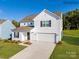 Charming two-story home with white siding, a two-car garage, and a well-maintained lawn on a sunny day at 1094 Old Trade St, Edgemoor, SC 29712