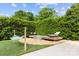 Backyard lounge space with hammock, lounge chairs, hot tub, gravel, and manicured hedges at 11 Secrest Ext, Belmont, NC 28012