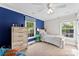 Comfortable bedroom with blue accent wall, natural light, and wood-finished furniture at 11 Secrest Ext, Belmont, NC 28012