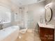 Elegant bathroom featuring a herringbone tile shower, soaking tub, and wood vanity at 110 River Wood Dr, Fort Mill, SC 29715