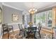 Dining room with a black table and seating for five, illuminated by a decorative chandelier at 110 River Wood Dr, Fort Mill, SC 29715