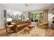 Bright living room with a brown leather sofa and views of the backyard at 110 River Wood Dr, Fort Mill, SC 29715