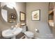 Stylish powder room with a modern sink, round mirror, and decorative shelves at 110 River Wood Dr, Fort Mill, SC 29715
