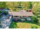 Aerial shot of brick home with carport, mature trees, and colorful front yard landscaping at 113 Princess Ln, Dallas, NC 28034