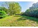 Expansive backyard with lush lawn, mature trees and a charming wooden fence offers privacy and space at 113 Princess Ln, Dallas, NC 28034