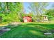 Spacious backyard featuring a red shed, greenery, and a fenced area, offering ample outdoor space and storage at 113 Princess Ln, Dallas, NC 28034
