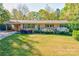 Charming brick home featuring blue shutters and colorful landscaping in the front yard at 113 Princess Ln, Dallas, NC 28034