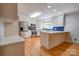 Well-lit kitchen featuring white cabinets, stainless steel appliances, hardwood floors, and a blue backsplash at 113 Princess Ln, Dallas, NC 28034