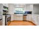 Modern kitchen featuring stainless steel appliances, farmhouse sink, and navy backsplash at 113 Princess Ln, Dallas, NC 28034