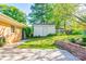 Backyard view with a shed, stone retaining wall, and concrete path, providing ample storage and functionality at 113 Princess Ln, Dallas, NC 28034