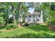 Spacious backyard with lush green lawn, mature trees, and a charming deck, perfect for outdoor relaxation at 1202 Foxfield Rd, Waxhaw, NC 28173