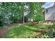A backyard is surrounded by a well-maintained lawn, a hammock, mature trees, and an outdoor seating area at 1202 Foxfield Rd, Waxhaw, NC 28173