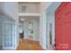 Inviting foyer featuring hardwood floors, a striking red front door, and views into the home at 1202 Foxfield Rd, Waxhaw, NC 28173