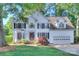 Beautiful two-story white home featuring manicured lawn, brick accents, and attached two-car garage at 1202 Foxfield Rd, Waxhaw, NC 28173
