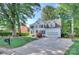 Traditional white home with a long driveway, lush green lawn and mature trees at 1202 Foxfield Rd, Waxhaw, NC 28173