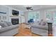 Open-concept living room offers a fireplace, large windows, hardwood floors, and comfortable seating at 1202 Foxfield Rd, Waxhaw, NC 28173