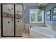 Beautiful bathroom with a glass-enclosed shower and a soaking tub by a sunlit window at 1202 Foxfield Rd, Waxhaw, NC 28173