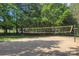 Sand volleyball court surrounded by mature trees, offering a fun recreational space for residents at 1202 Foxfield Rd, Waxhaw, NC 28173