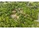 High aerial view of a wooded property with a long driveway, outbuildings, and proximity to other homes at 124 Neumann Run, Belmont, NC 28012