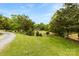 Grassy yard with trees, a road, and a small building at 124 Neumann Run, Belmont, NC 28012