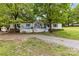 Charming home with a white porch, blue shutters, and well-maintained gravel driveway at 124 Neumann Run, Belmont, NC 28012