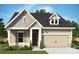 Charming home featuring neutral siding, gabled roof, attached garage and professionally landscaped yard at 1334 Idyllic Ln, Waxhaw, NC 28173