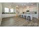Spacious kitchen with an island with bar seating, white cabinets, stainless appliances, and hardwood floors at 1334 Idyllic Ln, Waxhaw, NC 28173